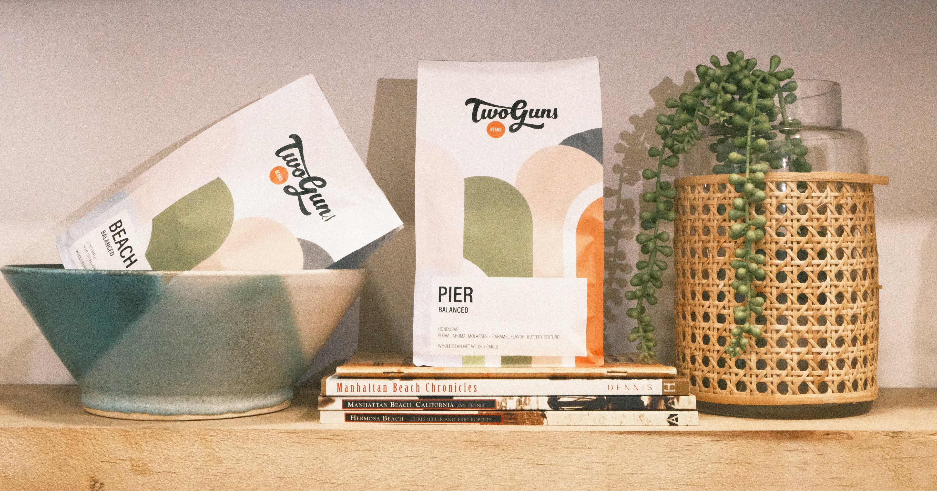 BAGS OF COFFEE BEANS ON A SHELF WITH HOUSEHOLD OBJECTS