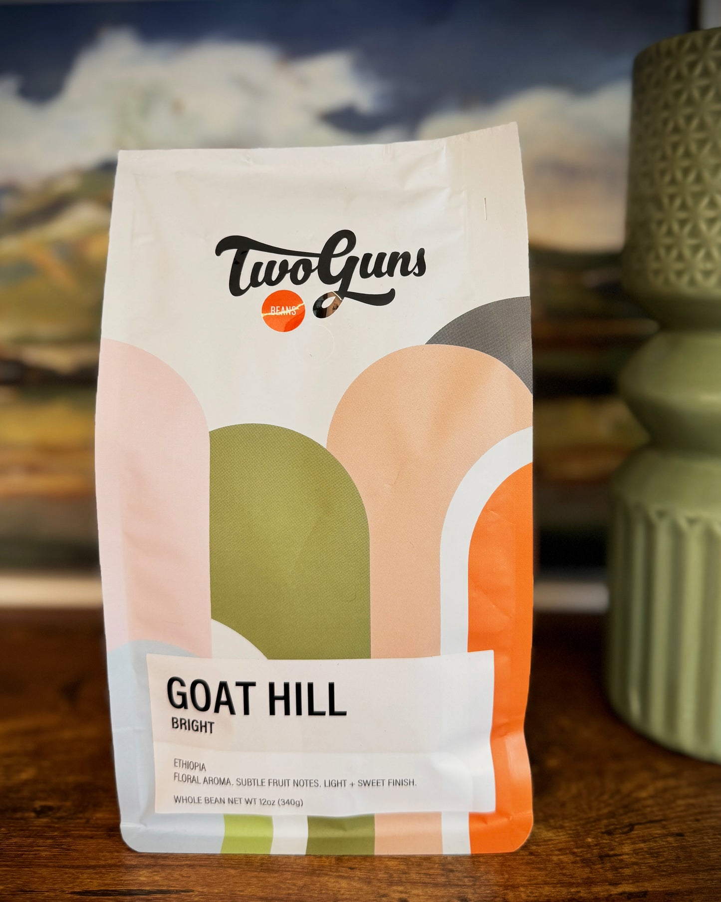 Two Guns Goat Hill coffee package on a wooden surface with a blurred background