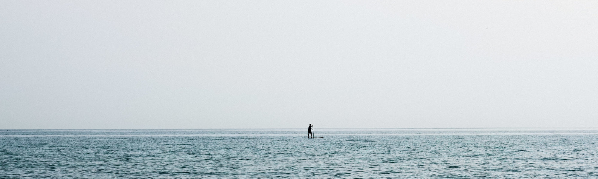 paddle boarder on a still lake