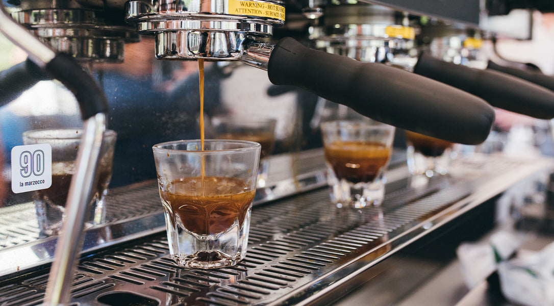 close up of espresso shot pouring into a shot glass